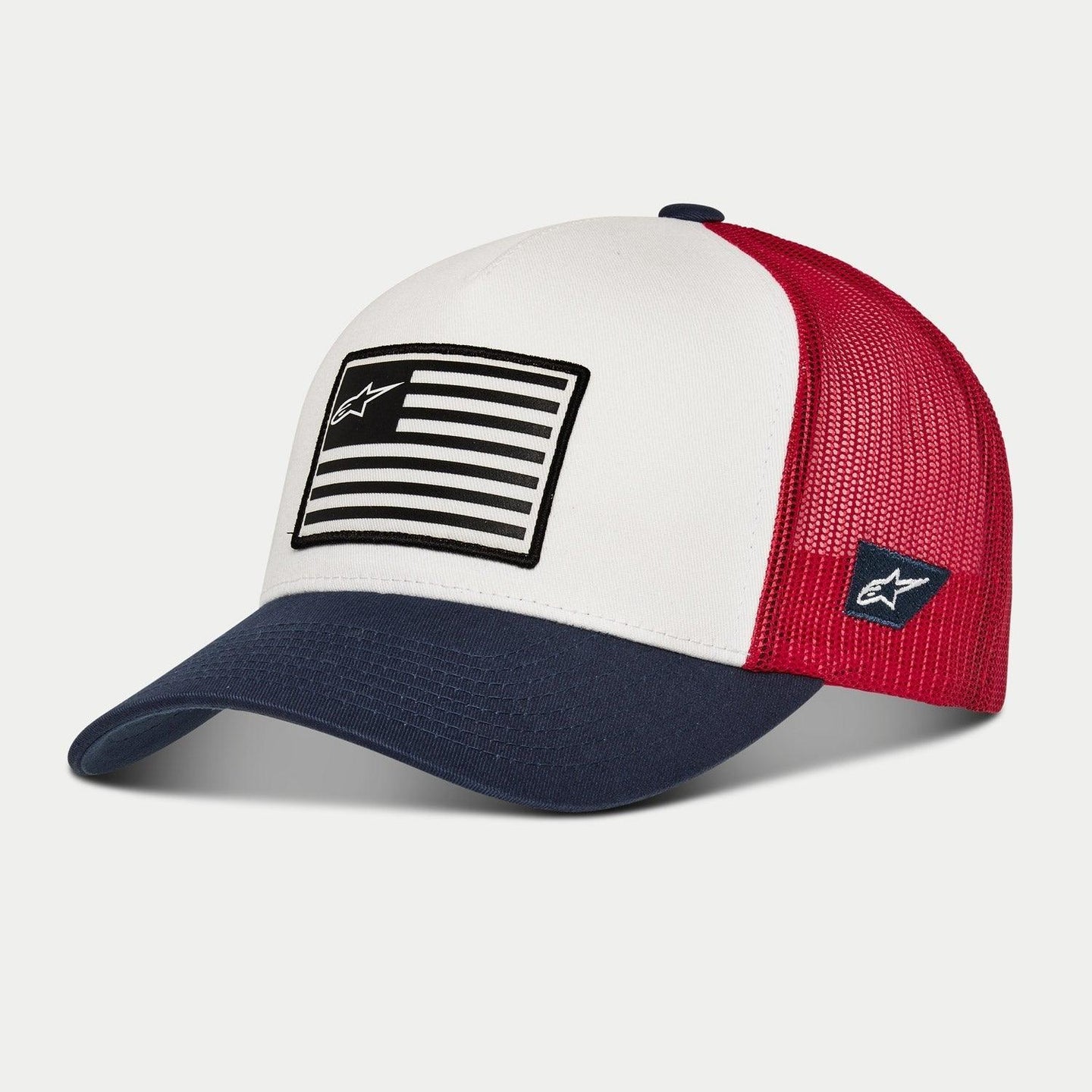 Alpinestars Flag Snapback Hat, White, Navy and Red, trucker-style cap with a curved navy brim, white structured front panel featuring a flag-inspired patch, and red mesh back, casual motorsport headwear