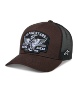 Alpinestars Heritage Patch Trucker Hat, Brown and Black, featuring a large front patch with winged wheel embroidery and 'RACING AHEAD EST. 1963' text, breathable black mesh back, curved brim, white side star logo, motorsport-inspired casual headwear