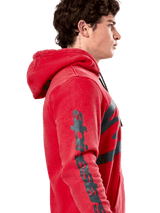 Alpinestars Unbound Hoodie, Red pullover fleece hoodie, side profile showing dark gray Alpinestars wordmark on the sleeve, garment-dyed finish with a drawstring hood, casual motorsport streetwear