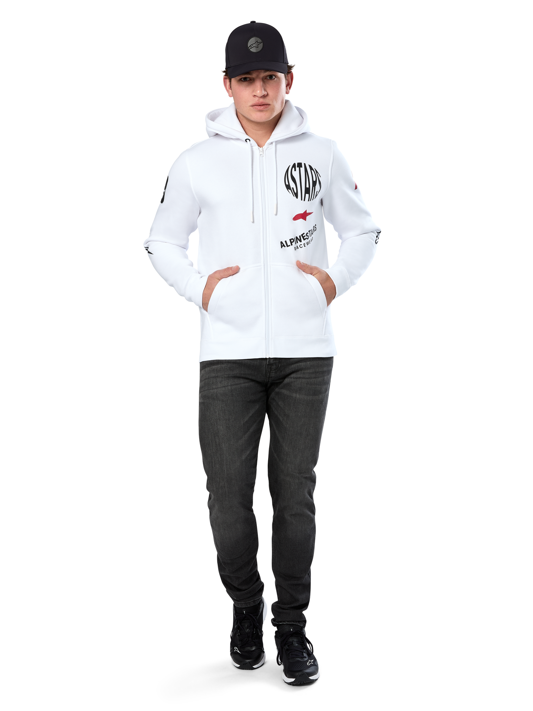 Alpinestars Variegate Hoodie, White Zip-Up Fleece Hoodie, multi-logo artwork with 'ASTARS' and red star logo on chest, graphic details on sleeves, worn by model with black cap and black jeans, casual motorsport streetwear
