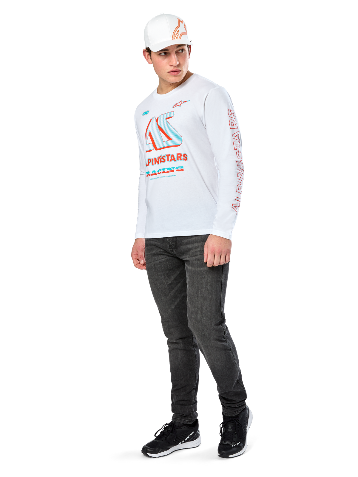 Alpinestars Ayess CSF Tee, Long Sleeve T-Shirt, White, featuring large blue and red CSF racing graphics on the chest and red Alpinestars branding on the sleeve, worn with dark jeans and a white Alpinestars cap, casual motorsport streetwear