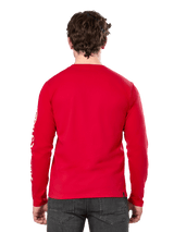 Rear view of a man wearing the Alpinestars Committed CSF Long Sleeve Tee in Red, paired with dark grey jeans, featuring a visible Alpinestars sleeve logo in white and a minimalist back design.