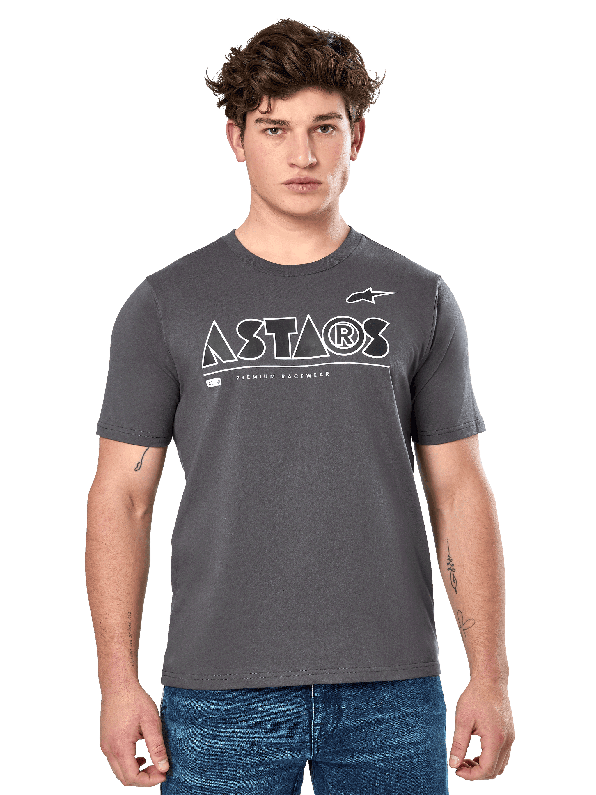 Alpinestars Cereal CSF Tee, Charcoal Gray Short Sleeve T-Shirt, worn by a male model with blue jeans, white ASTARS geometric logo and 'Premium Racewear' text, casual motorsport-inspired lifestyle apparel