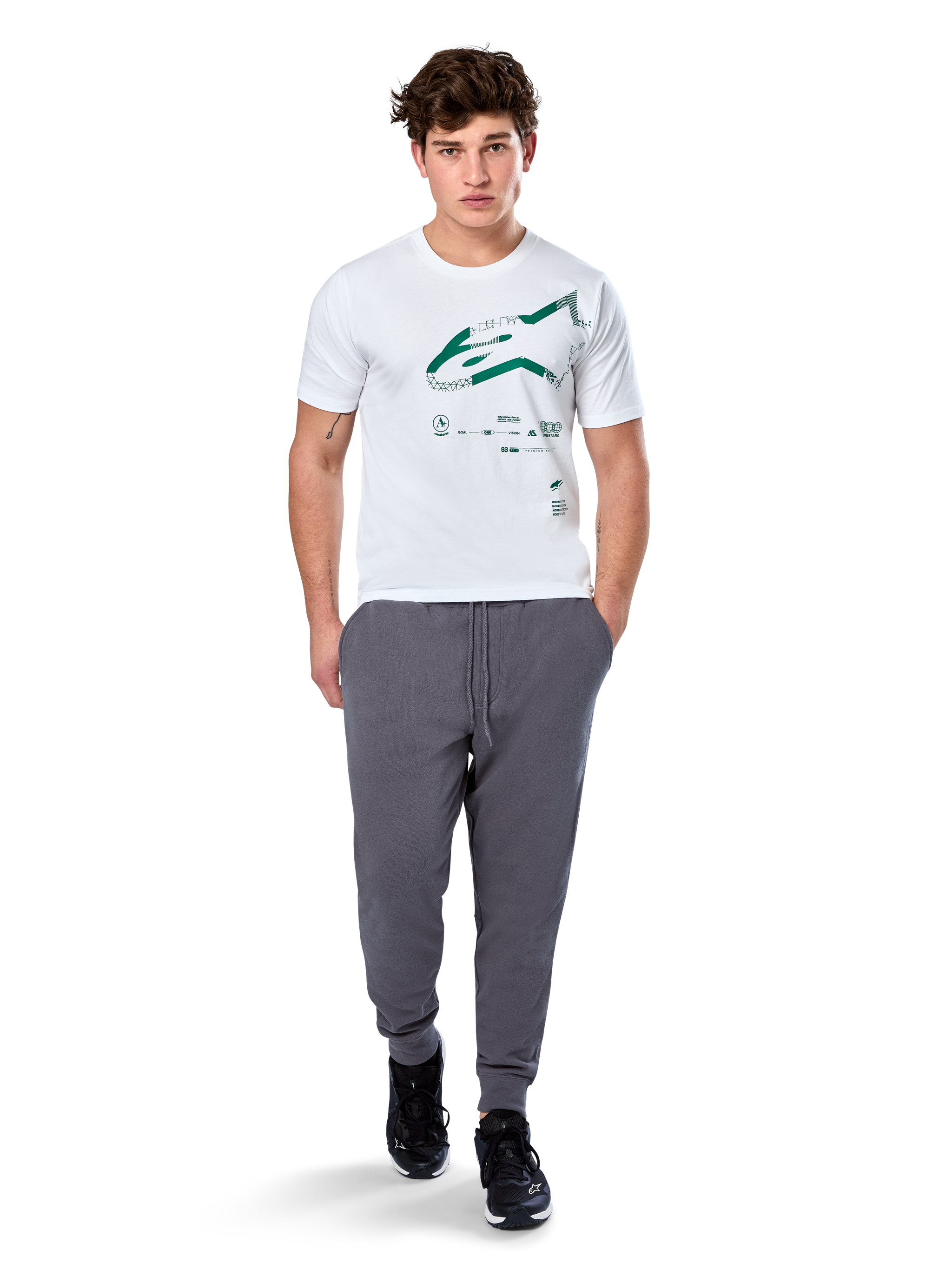 Alpinestars Geografica CSF Tee, Short Sleeve T-Shirt, White, Green Astars Logo with geographic multi-tech graphic, worn with grey sweatpants and black sneakers, casual motorsport streetwear