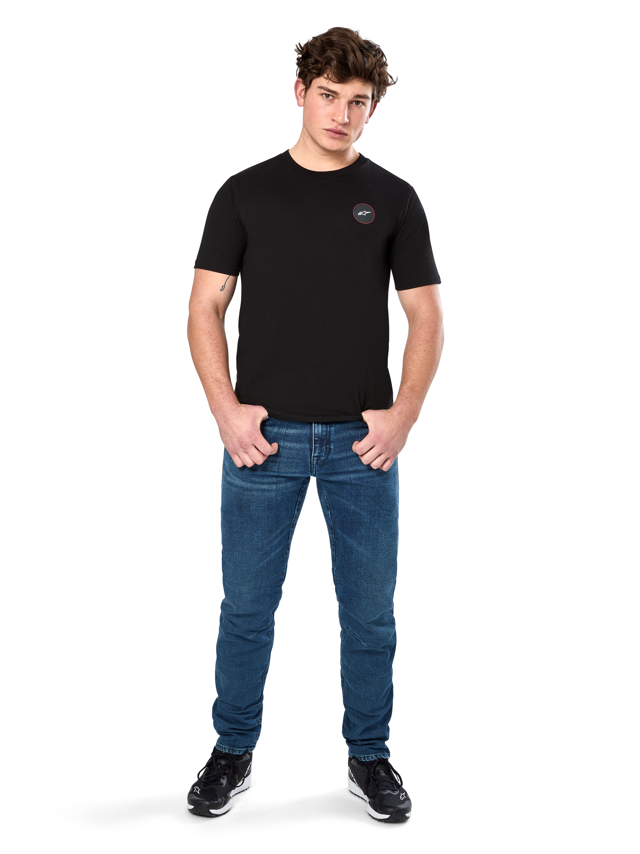 Alpinestars Dot Carbon CSF Tee, Short Sleeve T-Shirt, Black, Small Circular Astars Dot Logo on Chest, worn with blue jeans and black sneakers, casual motorsport streetwear