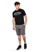 Alpinestars Prevail Csf Tee, Short Sleeve T-Shirt, Black, white Alpinestars logo with tri-color paddock stripe, worn with grey shorts and black sneakers, casual motorsport streetwear