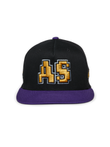 Alpinestars Franchise Hat, black and purple flat bill cap, structured crown with purple bill and top button, featuring a gold 3D embroidered "AS" logo on the front, casual motorsport-inspired streetwear