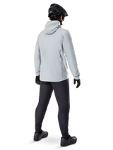 Alpinestars A-Dura Thermal Jacket in Titanium, back view of male cyclist wearing light gray hooded thermal jacket, paired with black MTB helmet, black gloves, and dark gray pants, functional mountain bike riding gear.