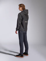 Alpinestars Speeder Chromium Windbreak Jacket, Black with white logo on the back, men's casual windbreaker with hood, side profile view worn with dark jeans and black sneakers, motorsport-inspired streetwear
