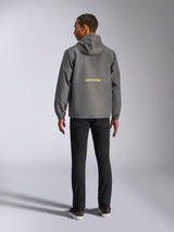 Alpinestars Speeder Chromium Windbreak Jacket, Charcoal and Hi Vis Yellow, back view showing yellow Alpinestars logo across the center, lightweight windbreaker with hood and elastic cuffs, casual motorsport-inspired streetwear