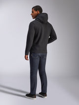 Alpinestars Blaze V3 Hoodie, back view of a man wearing the black pullover hoodie, paired with dark jeans and black sneakers, casual motorsport-inspired streetwear