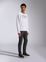Alpinestars Bettern Crew, White Pullover Sweatshirt, featuring black Alpinestars logo and 'Racing Ahead' red text, casual motorsport streetwear, worn by a model with dark pants and black sneakers