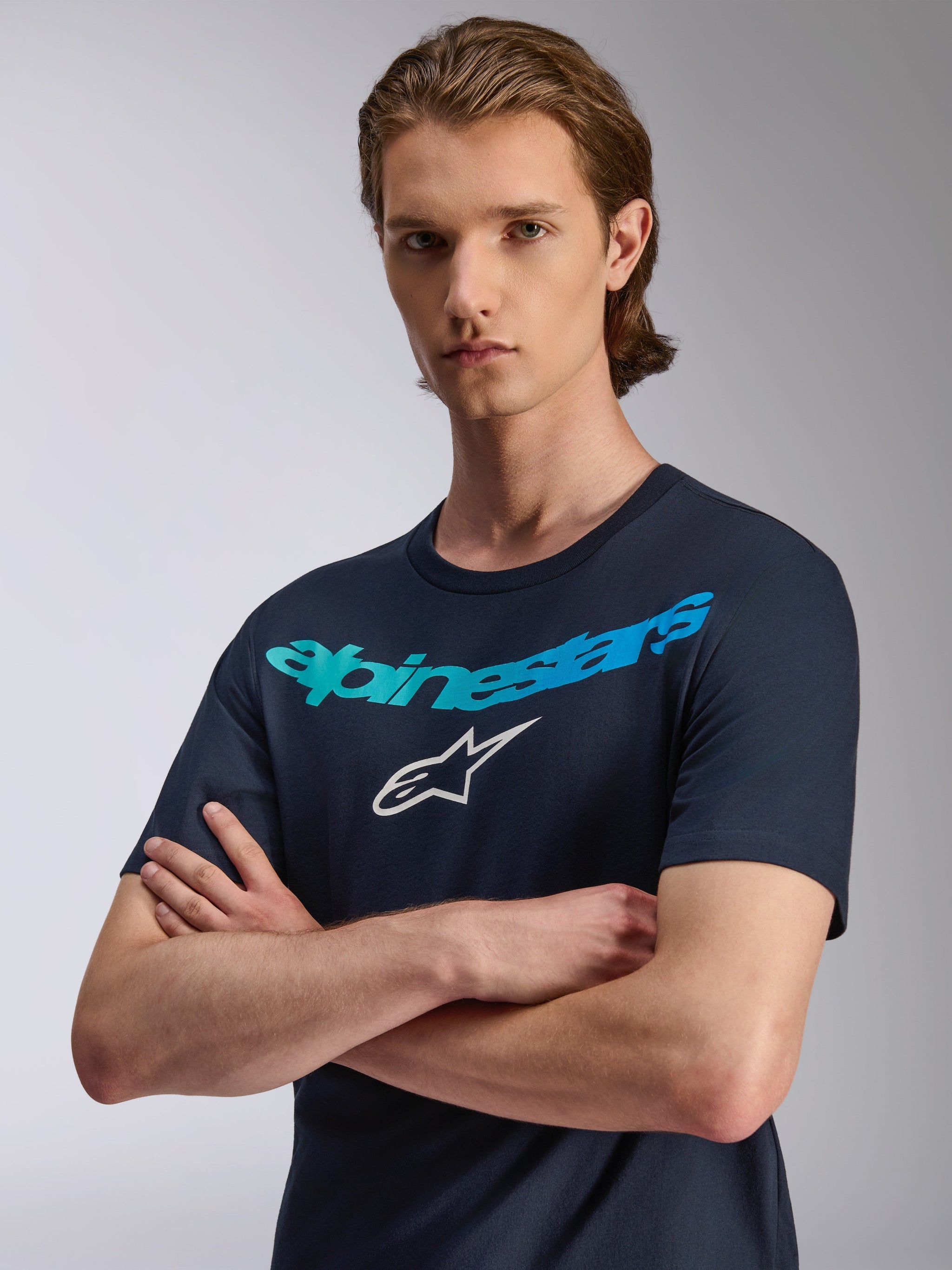 Alpinestars Collared CSF Tee, Short Sleeve T-Shirt, Navy Blue, Teal gradient Alpinestars wordmark and white star logo, worn by model with arms crossed, casual performance sportswear