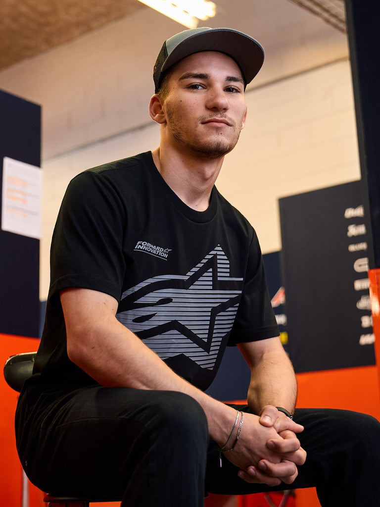Alpinestars Fasting CSF Tee, Short Sleeve T-Shirt, Black, Large Gray Geometric Star Logo with Forward Innovation text, worn by a man in a casual motorsport setting, Lifestyle Sportswear