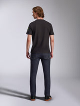 Alpinestars Entitled CSF Tee, Short Sleeve T-Shirt, Black, back view of a male model wearing the shirt with dark blue denim jeans, featuring a small white and green logo on the left sleeve, casual motorsport-inspired streetwear
