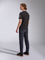 Alpinestars Entitled CSF Tee, Short Sleeve T-Shirt, Black, back-side profile of model wearing the tee with green and white sleeve logos, paired with dark denim and black sneakers, casual motorsport streetwear
