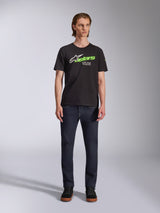Alpinestars Entitled CSF Tee, Short Sleeve T-Shirt, Black, featuring a white star logo, neon green 'stars' text, and 'Racing Ahead' graphic on the chest, worn by a model with dark jeans, casual motorsport-inspired apparel