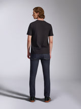 Alpinestars Global CSF Tee, Short Sleeve T-Shirt in Black, back view of male model wearing the shirt with dark denim jeans, casual motorsport-inspired streetwear