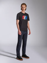 Alpinestars Global CSF Tee, Short Sleeve T-Shirt, Black with Red White and Blue Logo Graphic, Casual Motorsport Streetwear, Full body shot of model wearing dark jeans and black sneakers