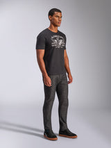 Alpinestars Heritage Patch CSF Tee, Short Sleeve T-Shirt, Black, White Winged Wheel 'Racing Ahead' graphic, worn by model with dark jeans and black sneakers, casual motorsport streetwear