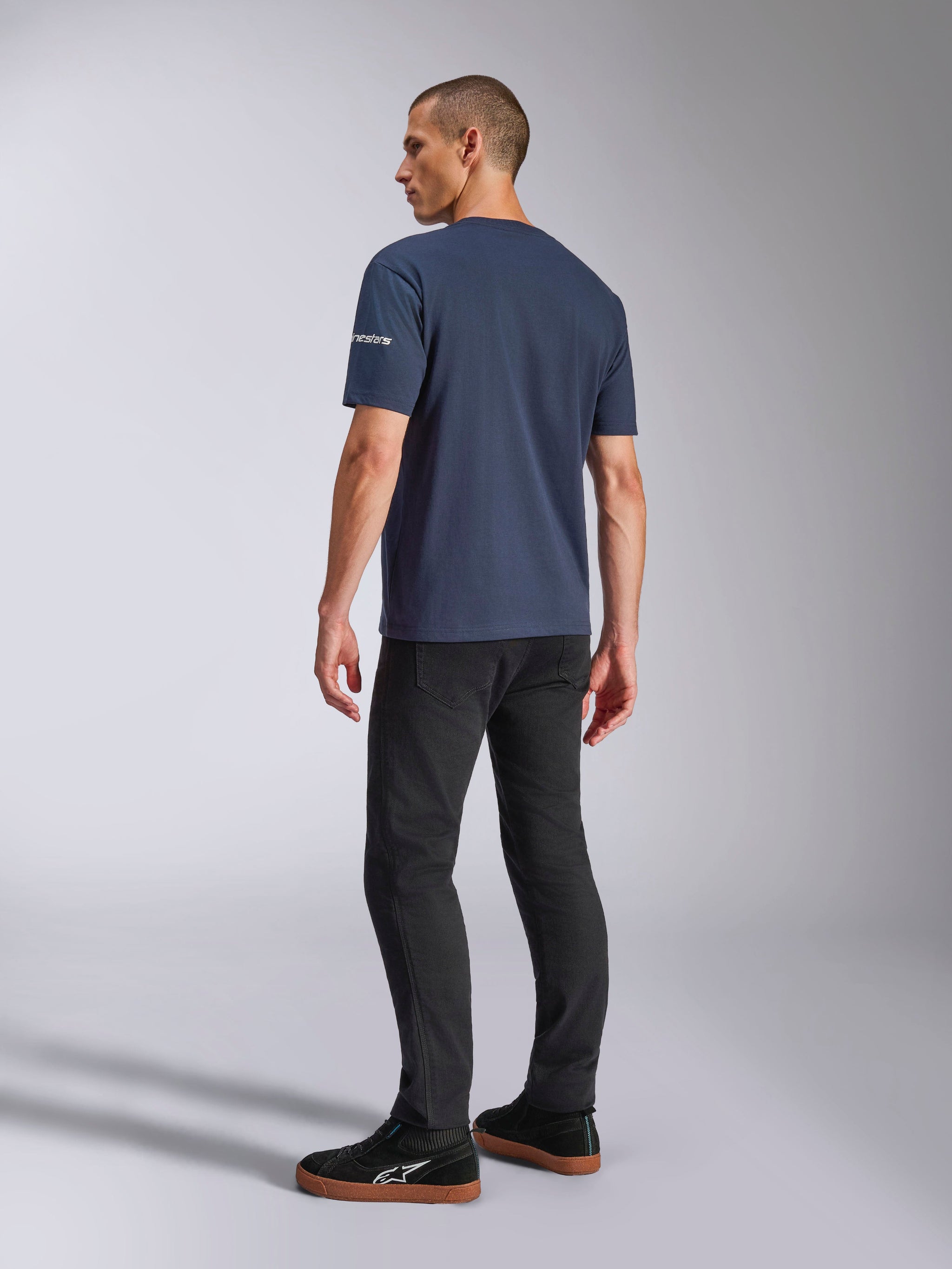 Alpinestars Frontal CSF Tee, Short Sleeve T-Shirt, Navy Blue, back view on model showing sleeve logo, worn with black pants and sneakers, casual motorsport-inspired streetwear