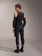 Male model from the back wearing Alpinestars A-Motion Plasma Protection Vest, Black Camo, sleeveless mesh design with integrated back protector, grey camo pattern on shoulders, worn with black elbow protectors and mountain bike shorts, professional cycling gear