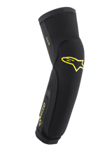 Alpinestars Paragon Plus Knee/Shin Protectors, Black with Acid Yellow logos, slip-on protective sleeve for MTB, featuring breathable mesh and reinforced rip-stop fabric, pre-shaped ergonomic fit for cycling