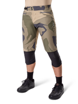 Alpinestars A-Dura Camo Liner Short, Mountain Bike Shorts, Brown Camo pattern, front view showing zippered pockets and side waist adjusters, worn with black knee pads and black cycling shoes, durable gear for MTB