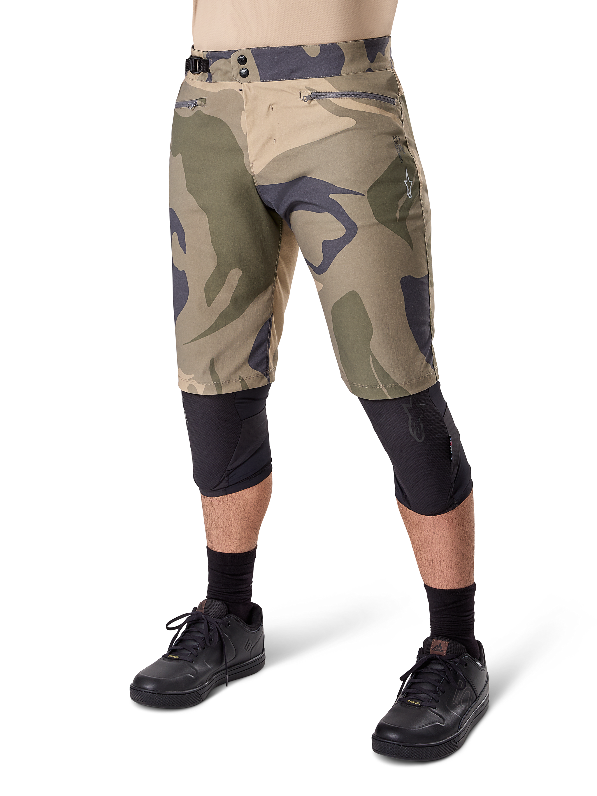 Alpinestars A-Dura Camo Liner Short, Mountain Bike Shorts, Brown Camo pattern, front view showing zippered pockets and side waist adjusters, worn with black knee pads and black cycling shoes, durable gear for MTB