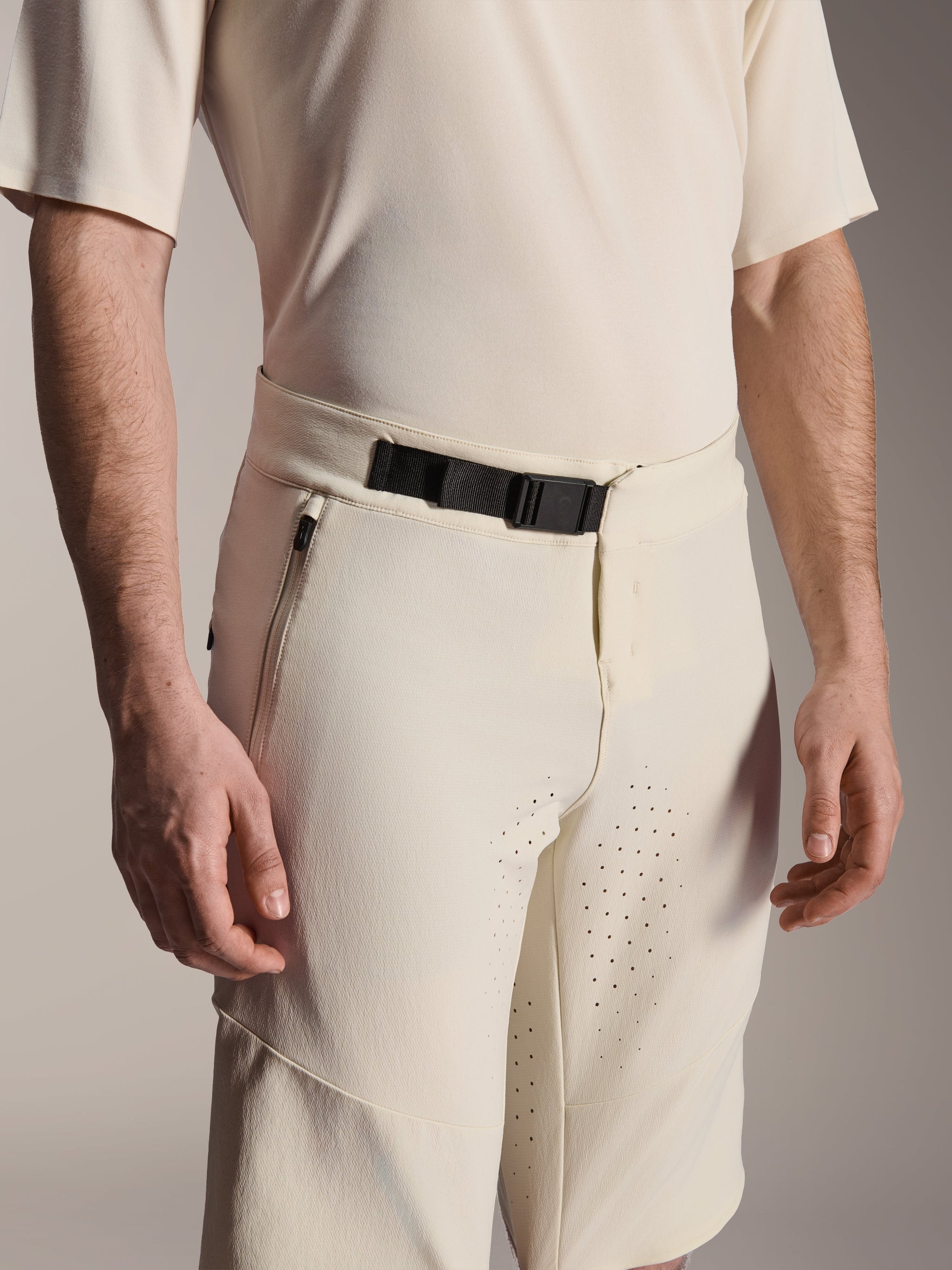 Alpinestars A-Aria Elite Shorts, Mountain Bike Shorts, Ecru, close-up view showing the black magnetic buckle closure, side zippered pocket, and laser-cut ventilation, technical performance cycling apparel