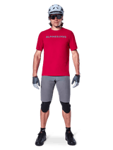 Alpinestars A-Aria Elite Shorts, Men's MTB Cycling Shorts in Dark Gray, with flexible stretch fabric and a red racing jersey.