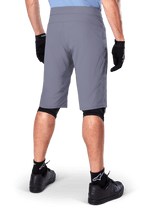 Alpinestars A-Dura Shorts, Dark Gray Mountain Bike Shorts, rear view shown on a rider, worn with black gloves, black knee liners, and black Alpinestars logo socks, durable construction for off-road cycling