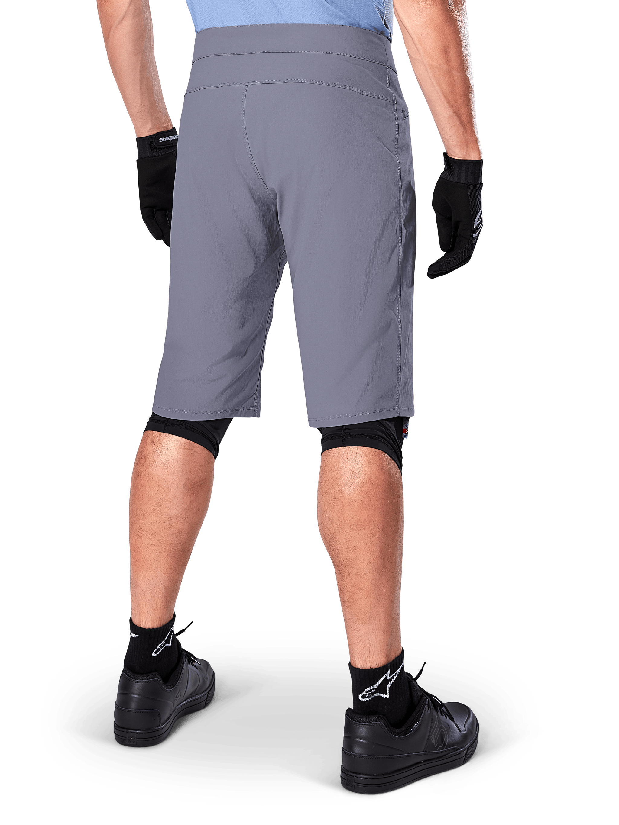 Alpinestars A-Dura Shorts, Dark Gray Mountain Bike Shorts, rear view shown on a rider, worn with black gloves, black knee liners, and black Alpinestars logo socks, durable construction for off-road cycling