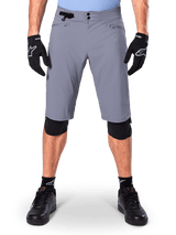 Alpinestars A-Dura Shorts, Mountain Bike Shorts, Dark Gray, worn with black Alpinestars gloves and knee pads, featuring double snap closure and zippered mesh-lined pockets, durable 2-way stretch fabric for off-road cycling