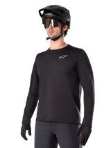Alpinestars A-Dura Thermal Jersey, Black long-sleeve mountain bike jersey, white chest logo, worn with black helmet and gloves, sleek sporty design for trail riding