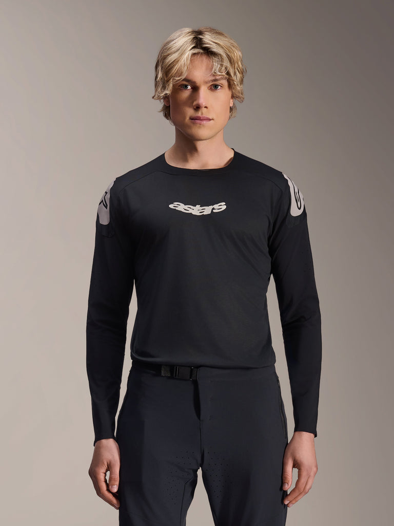 Alpinestars A-Aria Polartec Elite Jersey, Long Sleeve MTB Jersey, Black, featuring white 'astars' chest logo and white shoulder graphics, performance cycling gear worn by a model