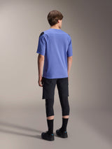 Alpinestars A-Aria Elite Shorts, Mountain Bike Shorts, Black Titanium, rear view worn with a lavender short-sleeve jersey, black knee guards, and black cycling shoes, athletic MTB gear setup.