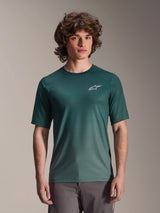 Alpinestars A-Dura Rise Jersey - Short Sleeve, Silver Pine dark green, worn by a model, featuring a white Astars logo on the chest, lightweight jacquard moisture-wicking fabric, casual mountain biking performance shirt