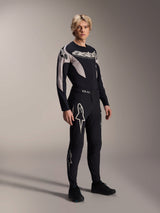 Male model wearing Alpinestars A-Supra Melt Jersey - Long Sleeve, Black with grey graphic accents, 'astars' chest logo, paired with matching black pants and shoes, performance mountain bike kit for off-road racing