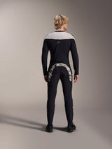 Man seen from behind wearing Alpinestars A-Supra Melt Long Sleeve Jersey in Black, light grey shoulder panel, paired with black MTB pants featuring a large Alpinestars logo across the rear, performance mountain bike kit
