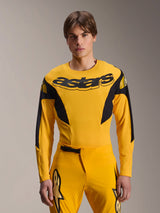 Alpinestars Limited Edition A-Supra Melt Gold Jersey, Long Sleeve MTB Jersey, Dark Yellow with black accents, worn by a model with matching pants, featuring large black 'astars' logo on the chest and athletic performance design