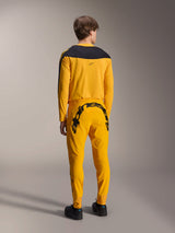 Alpinestars Limited Edition A-Supra Melt Gold Jersey, Long Sleeve MTB Jersey, Dark Yellow with black shoulder panel, worn with matching yellow pants featuring bold black branding on the back, rear view of performance cycling kit