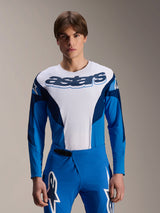 Alpinestars A-Supra Melt Jersey Long Sleeve, Blue and White MTB Jersey, featuring bold astars branding across the chest, dark blue sleeves, worn with matching blue racing pants with white star logos, performance mountain bike apparel