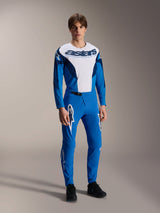 Male model wearing the Alpinestars A-Supra Melt Jersey - Long Sleeve in Blue and White, featuring a bold 'astars' logo on the chest, paired with matching blue mountain bike pants and black footwear, performance-oriented MTB racing apparel.