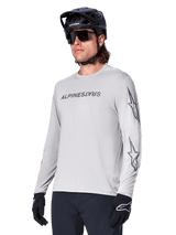 Alpinestars A-Dura Switch Long Sleeve Jersey, Mountain Bike Jersey, Light Gray, black wordmark screen print on chest and star logos on sleeves, worn with black mountain bike helmet, dark sunglasses, and black gloves, athletic off-road cycling gear