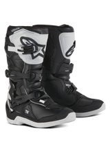 Alpinestars Youth Tech 3S Boots, Motocross Boots for young riders, Black and White, featuring three adjustable buckle straps, white TPU shin plate with Alpinestars logo, reinforced hard shell protection, and a sturdy white treaded sole, off-road racing design