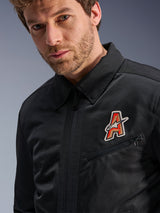 Alpinestars Ignite Air Jacket, Black, featuring a traditional shirt collar and breathable mesh construction, highlighted by a red and gold 'A' logo patch on the chest, worn by a male model, urban motorcycle apparel