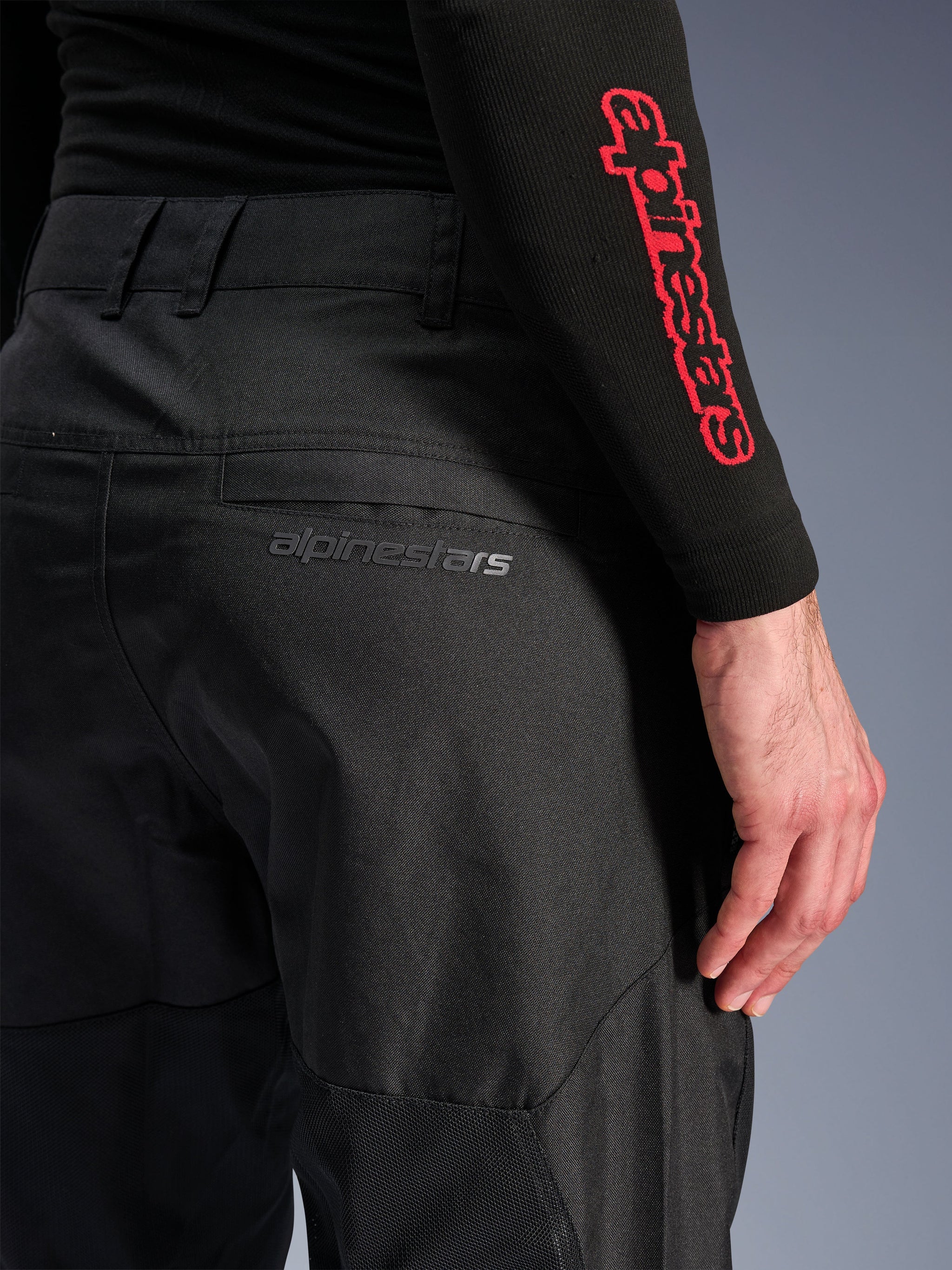 Alpinestars C-1 Air Pants, Black textile motorcycle pants, close-up view of the back pocket with a subtle grey Alpinestars logo, featuring breathable mesh panels and durable polyfabric, designed for urban riding comfort