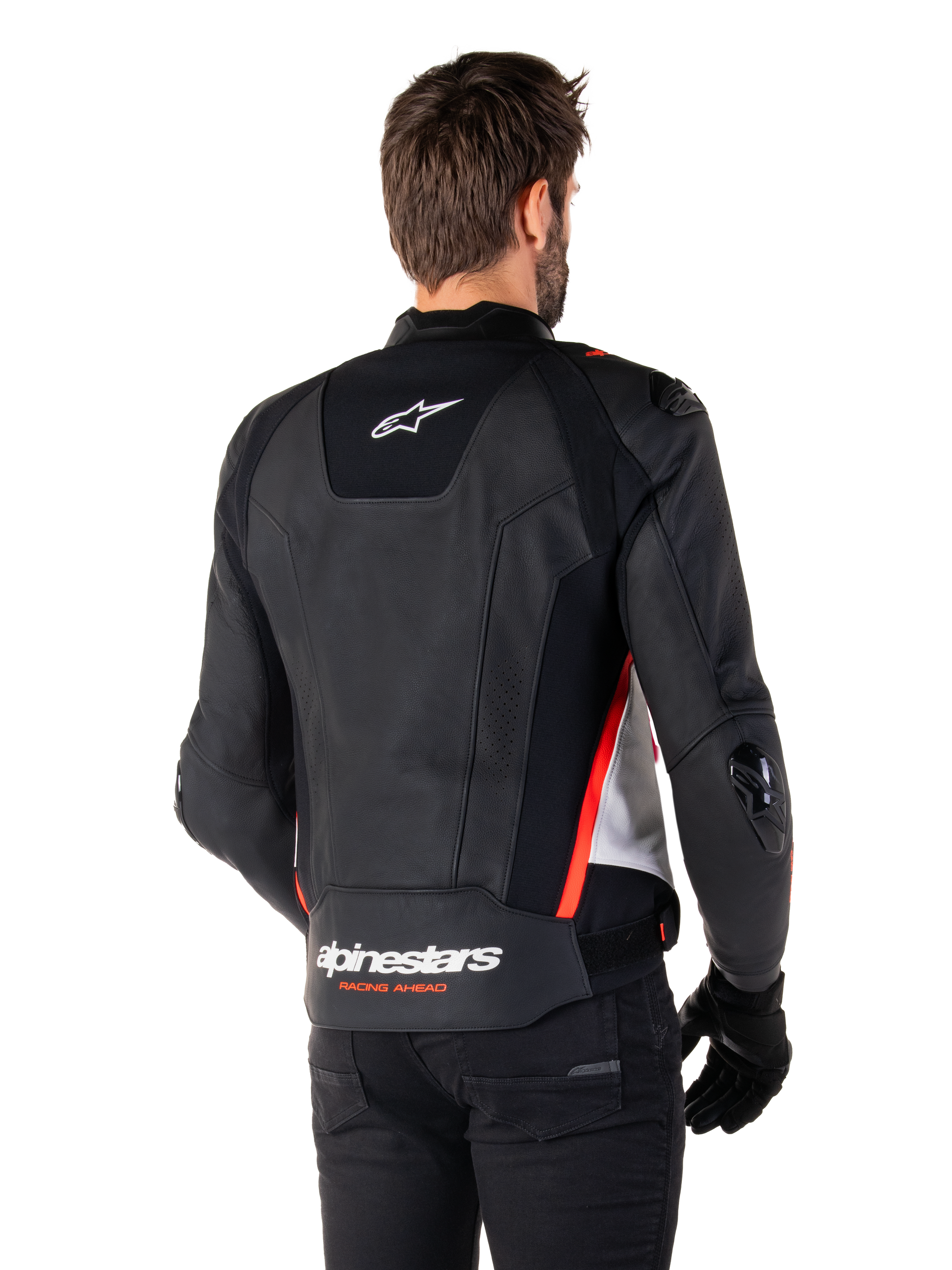 Alpinestars Missile V3 Leather Jacket, back view on a rider, Black White and Red Fluo, featuring bold Alpinestars branding and 'RACING AHEAD' text on the lower back, premium leather construction with technical stretch panels and protective TPU sliders, worn with black gloves and trousers.