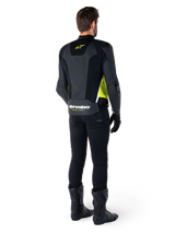 Alpinestars Missile V3 Airflow Leather Jacket, Black Yellow Fluo White, rear view on rider, featuring perforated leather back panels, yellow Alpinestars logo, and white accents, worn with black riding pants and boots
